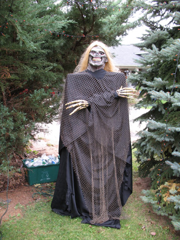 Another new one this year, my blonde fishnet ghoul.  A wood frame and a mask I've had a few years, combined with skeleton hands and covered in black material that used to be a couch cover (one of those you get for an old piece of furniture you want to cover).  Found the fishnet in the basement... It smells moldy, but in a graveyard that's not a bad thing!  Been looking to use the blonde wig for something for a few years.